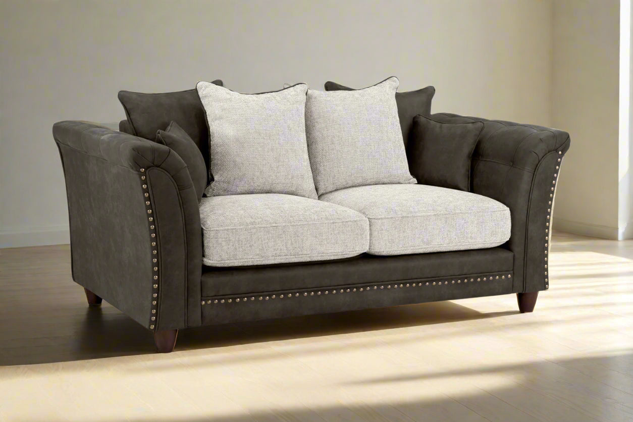 Bella Grey 2 seater sofa . Crafted with a blend of polyester and faux leather. scatter back cushions. removable cushions. stud detail around the frame