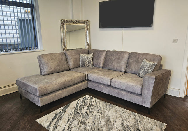 Gray sectional sofa in a room with a mirror and a screen displaying 'Aloespace Home Zone'.