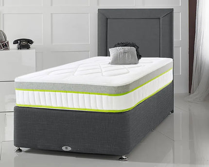 A single divan bed with a gray fabric upholstered headboard and a white mattress with yellow accents. 