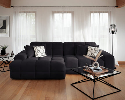 Modern living room with a black sectional sofa and glass coffee table.