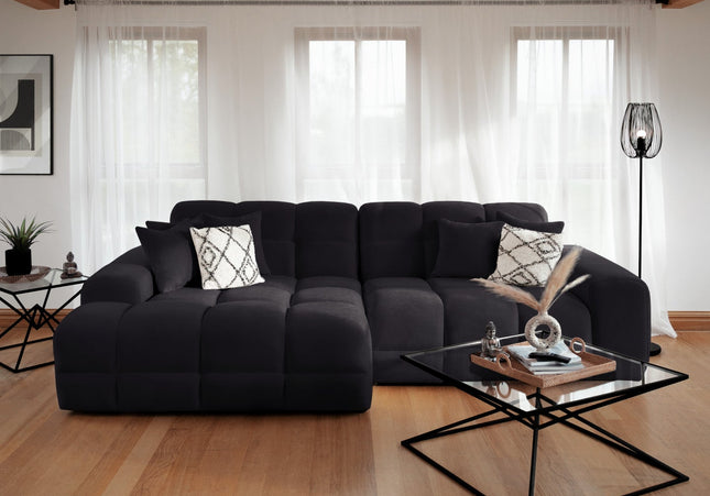 Modern living room with a black sectional sofa and glass coffee table.