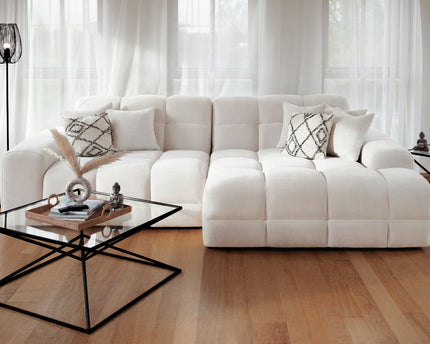 White sectional sofa in a living room with a coffee table and decorative items.