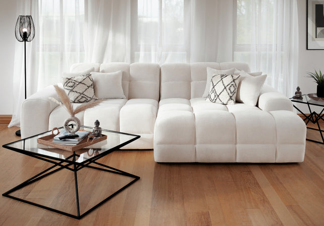 White sectional sofa in a living room with a coffee table and decorative items.