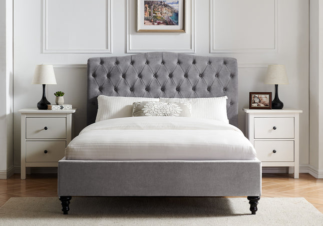 A double or king-size bed with a light gray upholstered headboard, 