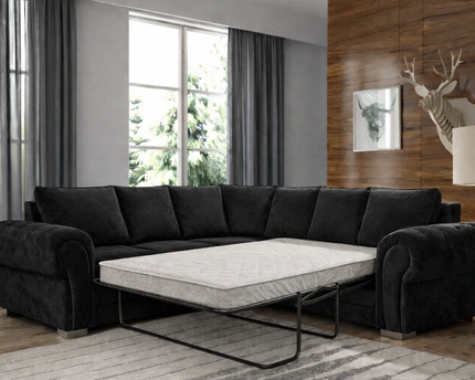 Black sectional sofa with a pull-out bed in a living room setting.