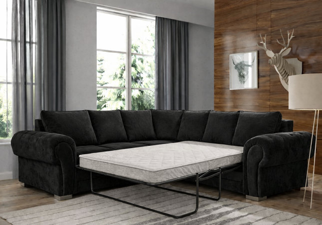 Black sectional sofa with a pull-out bed in a living room setting.