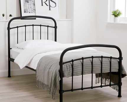 A single-sized black metal bed frame with a headboard and footboard