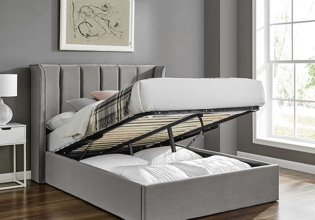 A Double ottoman bed with a winged headboard in silver color, featuring a storage compartment underneath, 