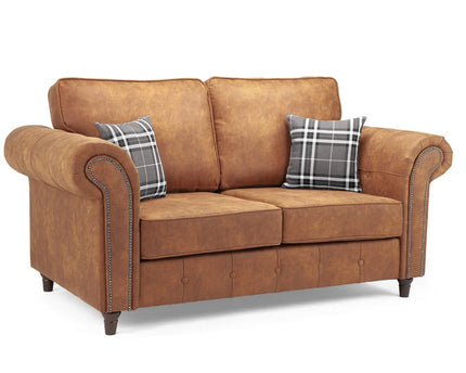 Oakmont 2 seater Sofa  - Tan,  faux leather 2 seater sofa is soft-to-the-touch and cosy, rounded arms with button detail and  metal studded up the front of the arm.