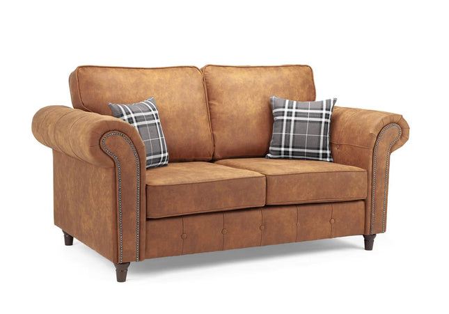 Oakmont 2 seater Sofa  - Tan,  faux leather 2 seater sofa is soft-to-the-touch and cosy, rounded arms with button detail and  metal studded up the front of the arm.