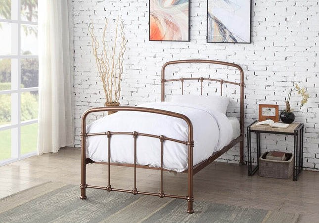 A single-sized copper-colored metal bed frame with a white mattress,