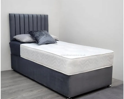 A single divan bed with a gray upholstered headboard and a white mattress, set on a gray fabric bed base.
